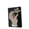 Embroidery art on small black notebook, collage of infected hand releasing flying bug