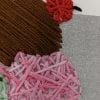 Embroidery art on black and white drawing of mountain tops, threaded green pink and brown ice cream with cherry on top