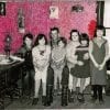 Embroidery art on black and white photo of family, threaded pink and red fuzzy wall