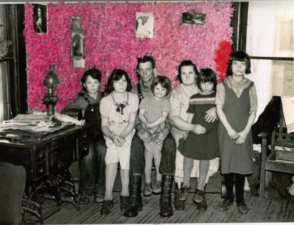 Embroidery art on black and white photo of family, threaded pink and red fuzzy wall
