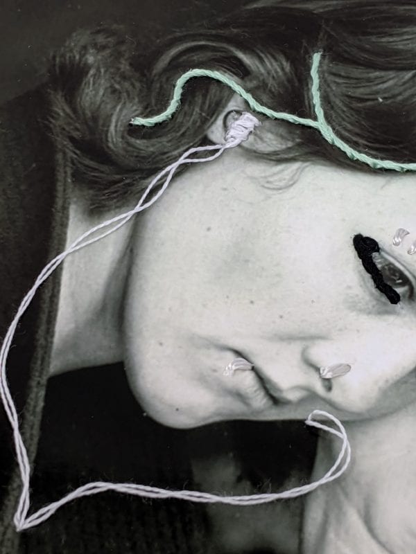 Embroidery art on black and white photo by Dorothea Lange, threaded headphones and facial piercings in woman's ears